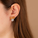 model wearing gold bow stud earrings with cubic zirconia heart - non tarnish - waterproof