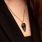 Model wearing raw black obsidian crystal pendant - gold plated edging - gold curb chain