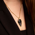 Model wearing raw black obsidian crystal pendant - gold plated edging - gold curb chain